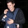 Orlando Bloom souriant en compagnie de son fils Flynn à l'aéroport de Los Angeles le 13 avril 2012
