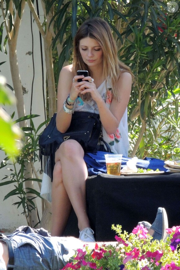 L'actrice Mischa Barton en tête à tête avec son iPhone 4S lors du Festival de Coachella. Indio, le 14 avril 2012.