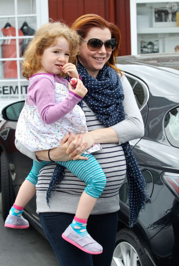 Alyson Hannigan, souriante avec sa fille Satyana dans les bras, au cours d'un après-midi shopping à Los Angeles, le 25 avril 2012.