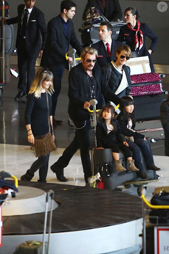 Très chargés, Johnny Hallyday, Laeticia et leurs fillettes arrivent à Paris depuis Los Angeles, le 5 mai 2012.