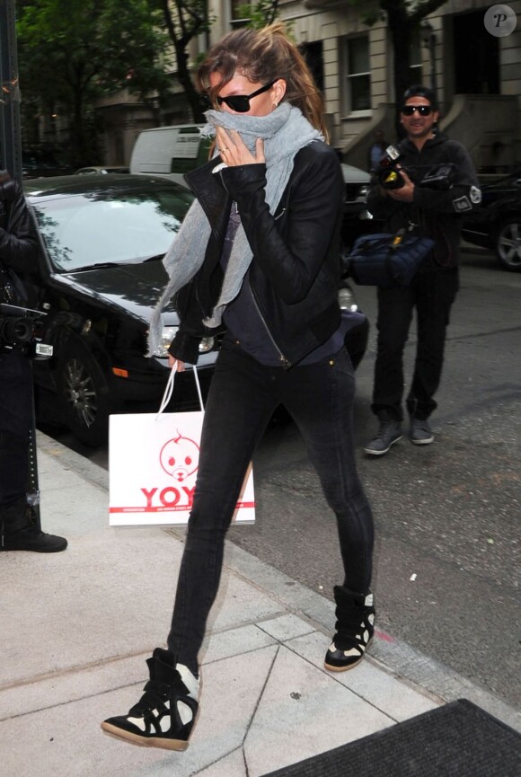Gisele Bündchen, camouflée derrière son écharpe, arbore les rues new-yorkaises avec style, habillée d'une veste en cuir, d'un slim noir et de baskets Isabel Marant. Le 7 mai 2012.