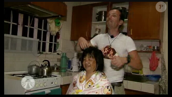 Joël offre ses talents de coiffeur aux jeunes femmes qui l'accueillent dans la bande-annonce de Pékin Express - Le Passager Mystère sur M6 mercredi 23 mai 2012