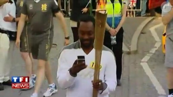 Will.i.am porte la flamme olympique dans les rues de Tauton dans le Somerset le 21 mai 2012