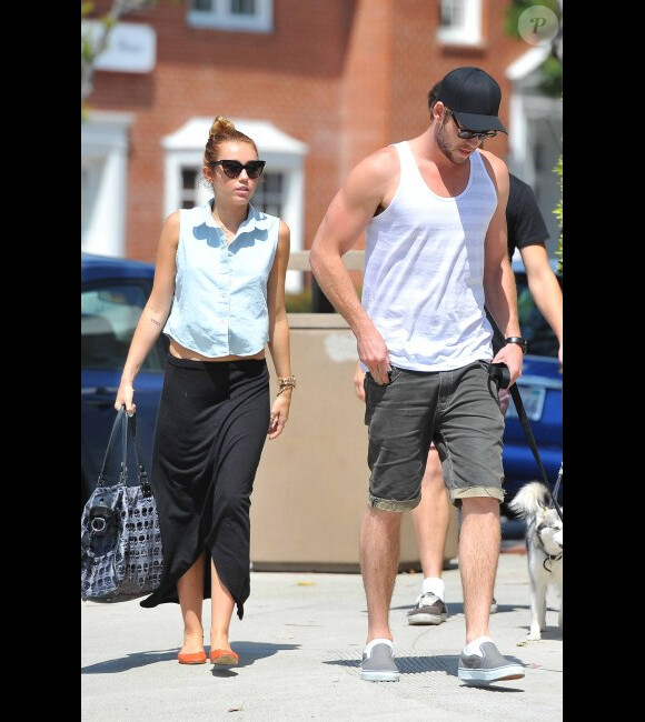 Miley Cyrus se promène avec Liam Hemsworth et leur chien Happy, le samedi 12 mai 2012.