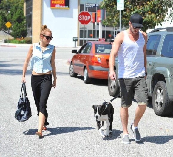 Miley Cyrus et Liam Hemsworth promènent leur chien Happy, le samedi 12 mai 2012, à Los Angeles.