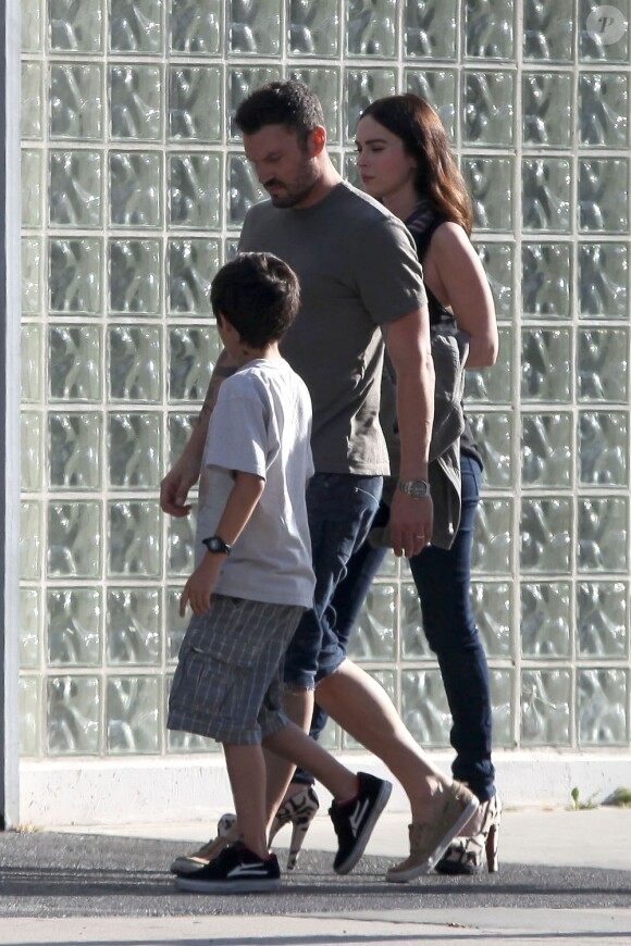 Megan Fox se sert de son blazer pour dissimuler son ventre rond. Ici, avec son époux Brian Austin Green et le fils de l'acteur. Dimanche 17 juin à Los Angeles.
