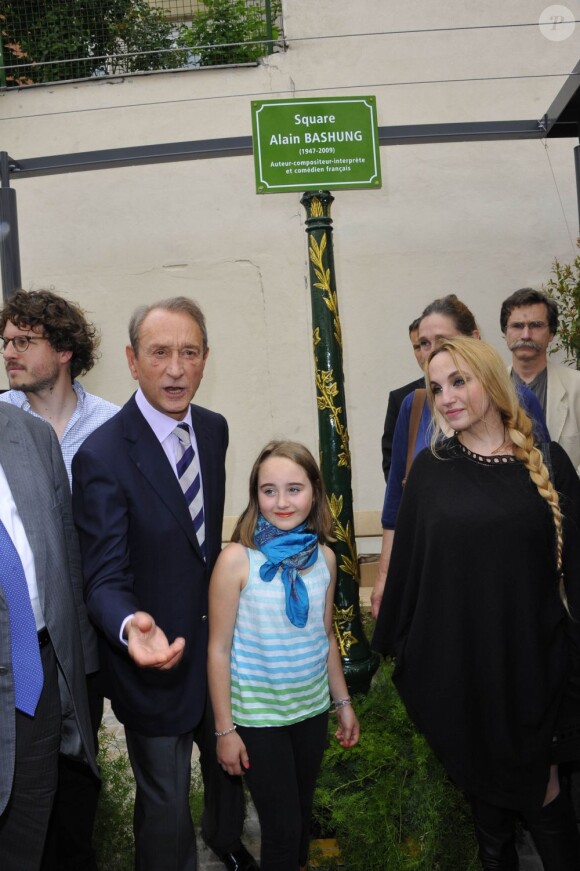 Bertrand Delanoë dévoile la plaque officielle devant Chloé Mons et sa fille Poppée à l'inauguration du square Alain-Bashung, dans le 18e arrondissement de Paris, le 21 juin 2012.