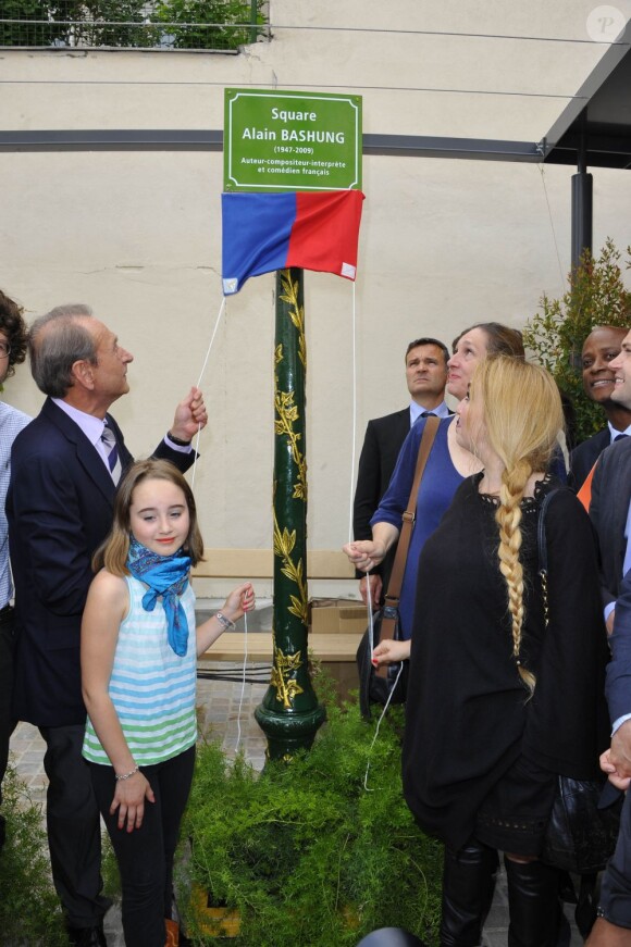 Bertrand Delanoë dévoile la plaque officielle devant Chloé Mons et sa fille Poppée à l'inauguration du square Alain-Bashung, dans le 18e arrondissement de Paris, le 21 juin 2012.
