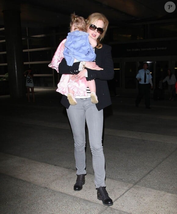 Nicole Kidman protectrice, porte sa fille Faith dans les bras. A l'aéroport de Los Angeles, le 22 juin 2012.