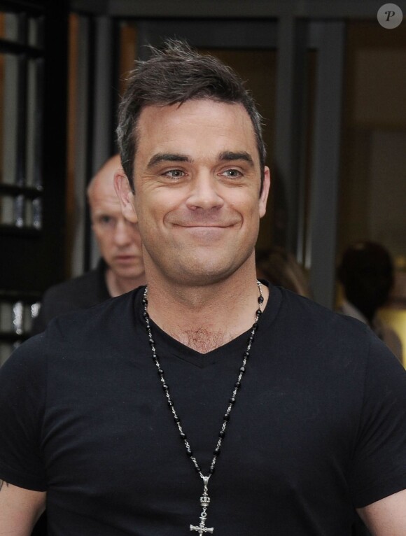 Un souriant Robbie Williams à la sortie des studios de Radio One à Londres, le 10 septembre 2012.