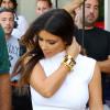 Kim Kardashian en top blanc, pantalon en cuir noir et bracelets dorés, quitte une boutique Vespa, suivie par les caméras de Keeping Up With The Kardashians. Miami, le 13 octobre 2012.