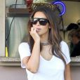 Kim Kardashian, une star stylée en lunettes et collier Céline, top blanc, jupe en cuir et bottines noires à Miami. Le 12 octobre 2012.