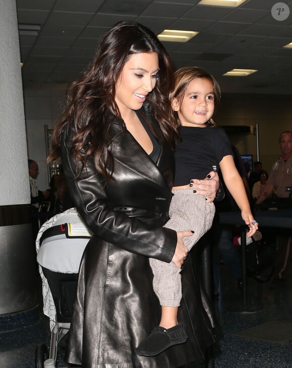 Kim Kardashian, une tante sexy et souriante à l'aéroport de Miami avec son neveu Mason. Le 6 novembre 2012.
