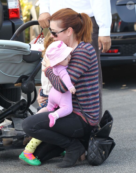 retour à la normale après Halloween, Alyson Hannigan porte ses deux filles Satyana et Keeva dans ses bras. Brentwood, le 7 novembre 2012.