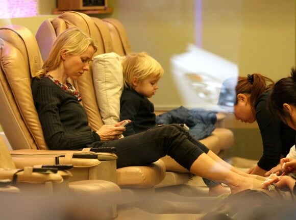 Naomi Watts occupée sur son téléphone et son fils Samuel en pleine séance de pédicure dans un salon new-yorkais, le 20 décembre 2012.
