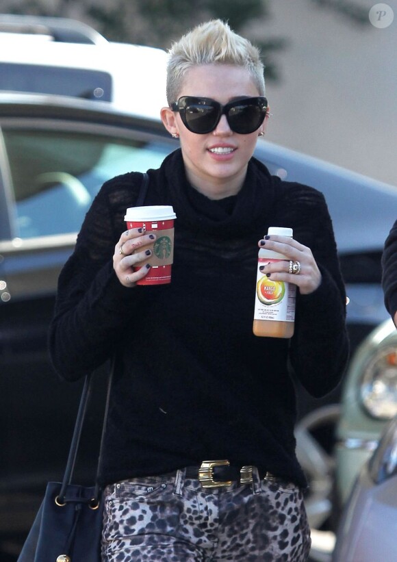 Exclusif - Miley Cyrus souriante, quitte une boutique Starbucks d'où elle sort avec des boissons à emporter. Los Angeles, le 22 décembre 2012.
