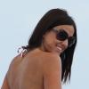 La sexy Claudia Romani, habillée d'un bikini rayé et à pois et d'une jupe rouge très courte, profite d'une belle journée sur la plage à Miami. Le 26 décembre 2012.
