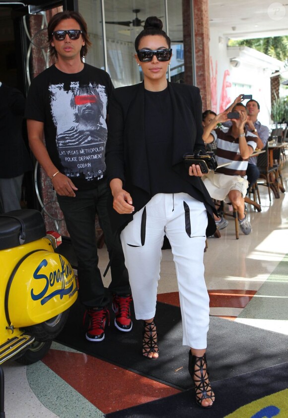 Kim Kardashian, enceinte, quitte le restaurant Serafina avec son ami Jonathan Cheban, habillée de lunettes et un top noirs Céline, une veste et un pantalon Helmut Lang et des bottines Givenchy. Miami Beach, le 7 janvier 2013.