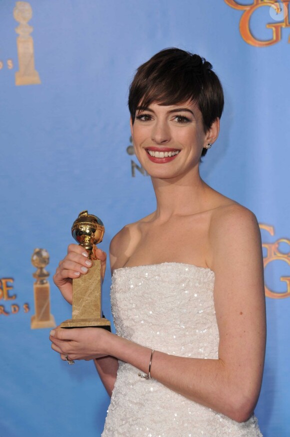 Anne Hathaway et son trophée pendant les Golden Globes le 13 janvier 2013.