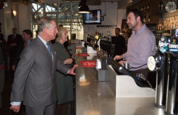Le prince Charles et Camilla Parker Bowles en visite à la station de Kings Cross rénovée et son immense pub le 30 janvier 2013, dans le cadre de leur visite dans le métro de Londres, à l'occasion du 150e anniversaire du réseau en 2013.