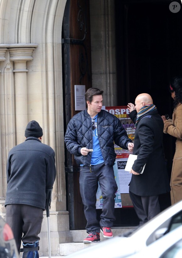 Mark Wahlberg salue un passant à la sortie de la Cathédrale américaine de la Sainte Trinité à Paris, le 3 février 2013.