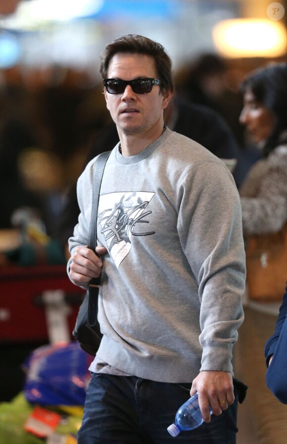 Bouteille d'eau à la main, sac à dos sur l'épaule droite, Mark Wahlberg arrive à l'aéroport de Paris le 2 février 2013.