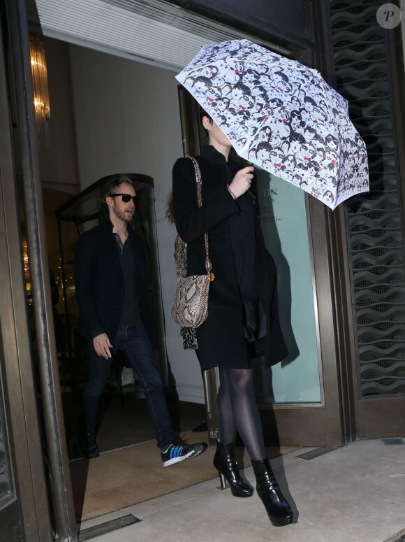 Accompagnée d'Adam Shulman derrière elle, Anne Hathaway ressort de la boutique de luxe Lanvin à Paris, le 7 février 2013.