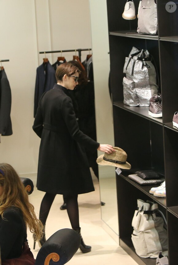 Anne Hathaway repose un chapeau en paille dans la boutique Lanvin à Paris, le 7 février 2013.