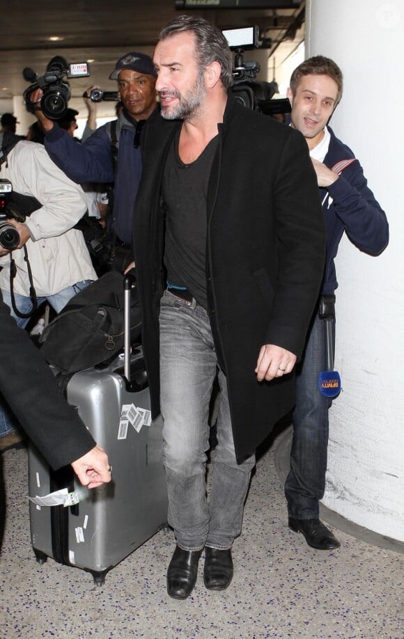 Jean Dujardin suivi par une horde de spectateurs et paparazzi au LAX de Los Angeles le 21 février 2013.