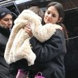 Suri Cruise et Katie Holmes dans les rues de New York, le 8 mars 2013. La petite fille ne daigne pas mettre un pied sur le sol à cause de la neige.