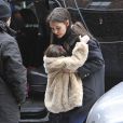 Suri Cruise et Katie Holmes dans les rues de New York, le 8 mars 2013. La petite fille fait un caprice et ne daigne pas mettre un pied sur le sol à cause de la neige.