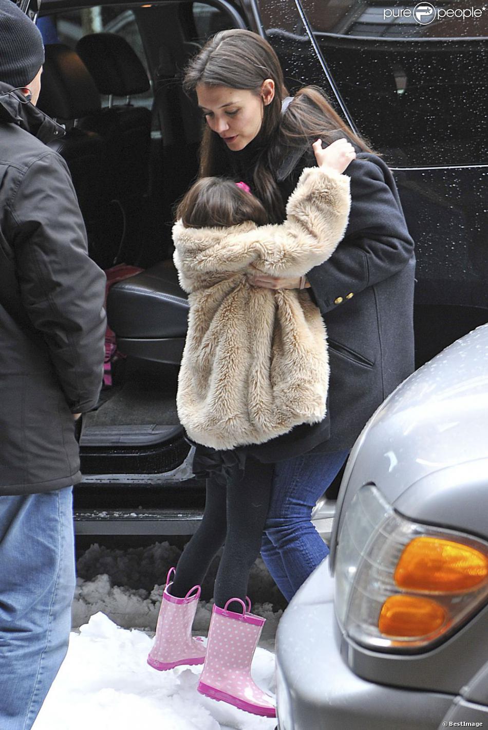 Suri Cruise et Katie Holmes dans les rues de New York, le 8 mars 2013. La petite fille fait un caprice et ne daigne pas mettre un pied sur le sol à cause de la neige.