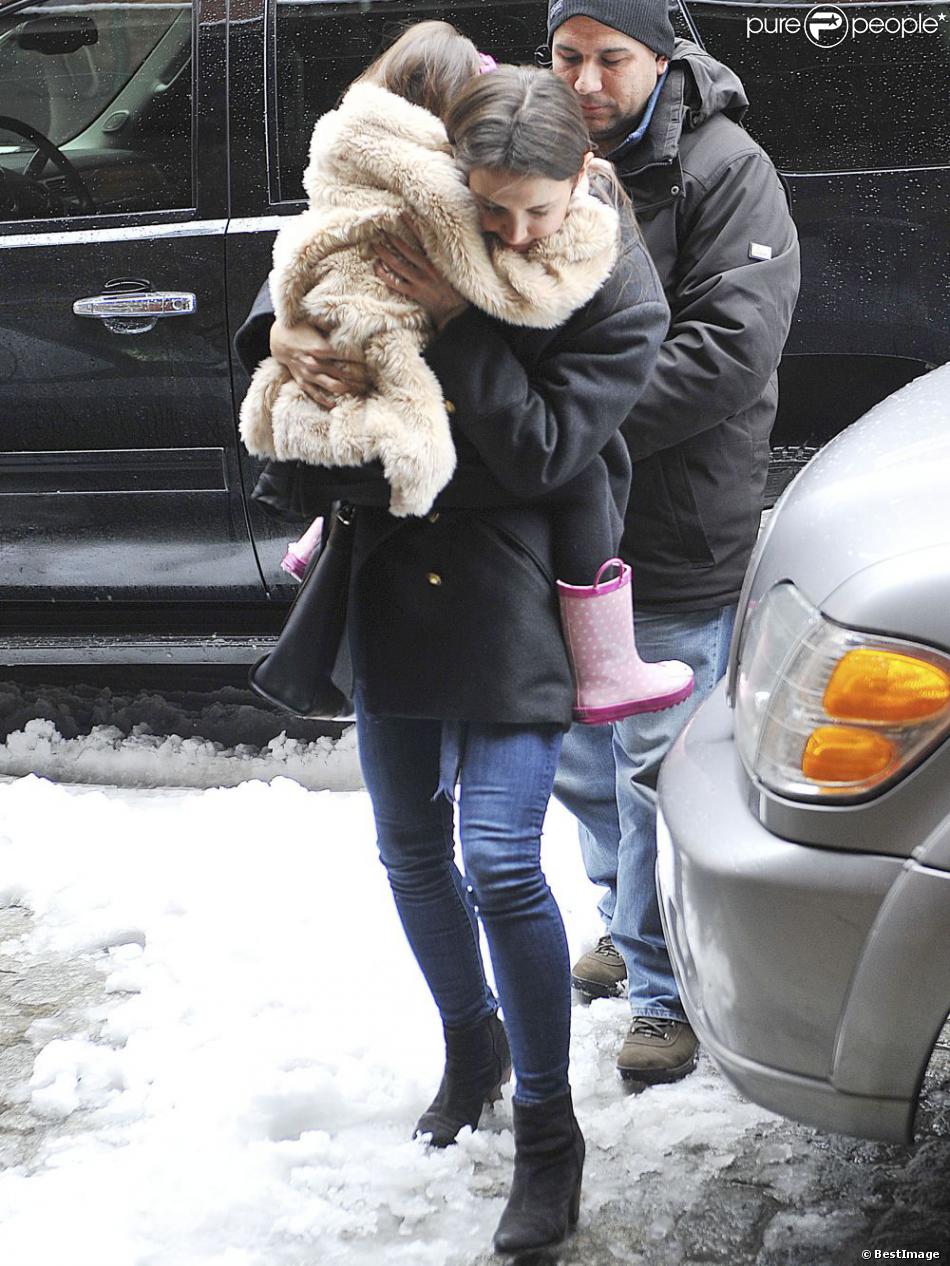 Suri Cruise portée par sa maman Katie Holmes dans les rues de New York, le 8 mars 2013. La petite fille ne daigne pas mettre un pied sur le sol à cause de la neige.