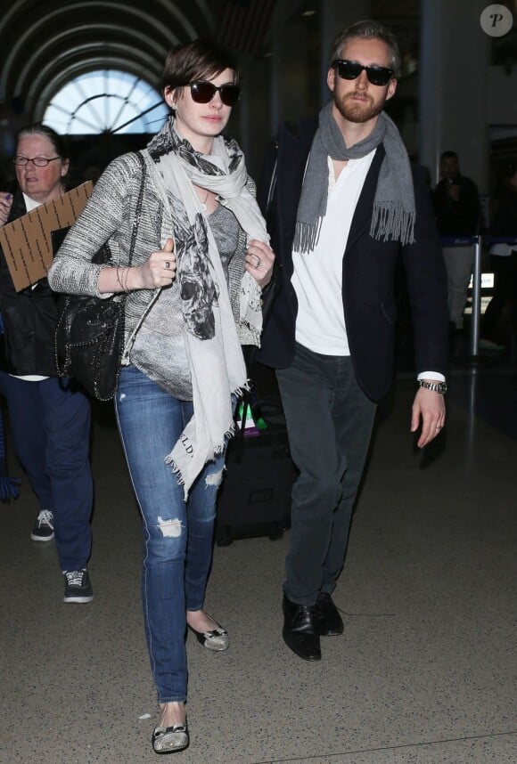 Anne Hathaway et son mari Adam Shulman arrivent à l'aéroport de Los Angeles, le 13 mars 2013.