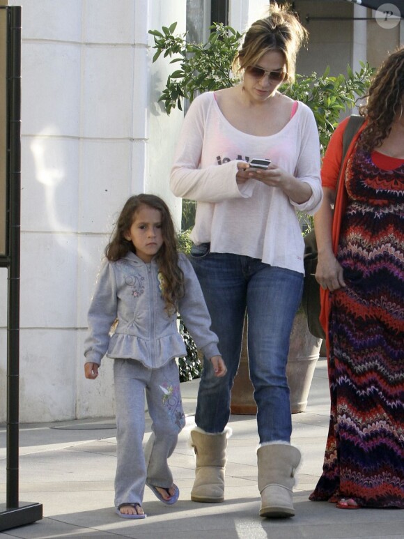 Jennifer Lopez, captivée par son téléphone portable, alors qu'elle fait des courses au supermarché avec ses enfants Max et Emme à Los Angeles, le 15 mars 2013.