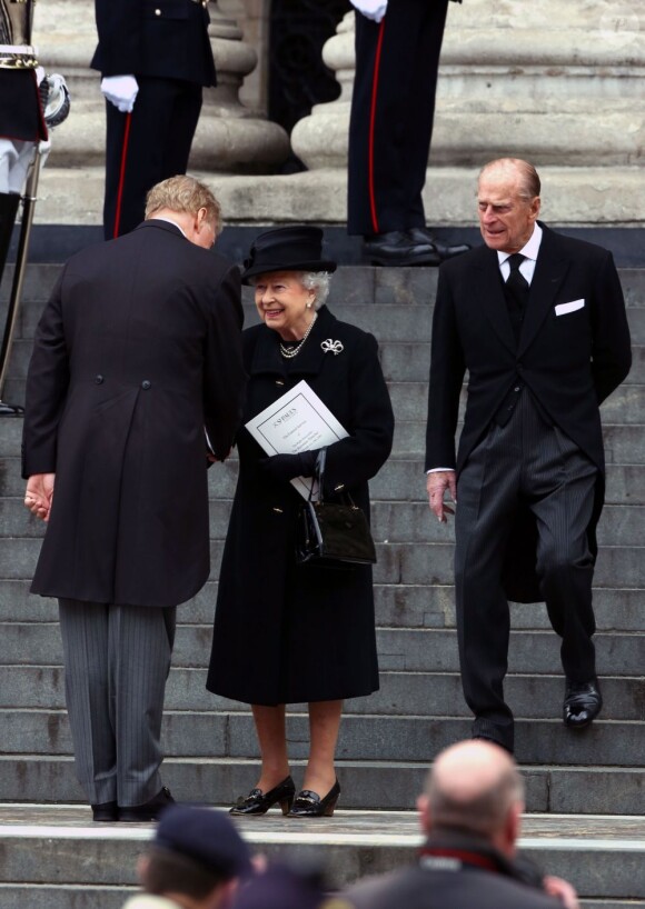 Sir Mark Thatcher saluant la reine Elizabeth II et le duc d'Edimbourg à quelques minutes de l'arrivée du cercueil de Margaret Thatcher pour ses funérailles, célébrées le 17 avril 2013 en la cathédrale St Paul de Londres.