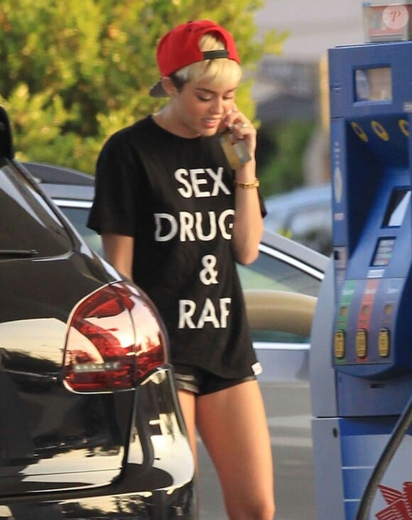 Exclusif - Miley Cyrus fait le plein de son 4x4 Porsche Cayenne à Los Angeles. Le 30 avril 2013.
