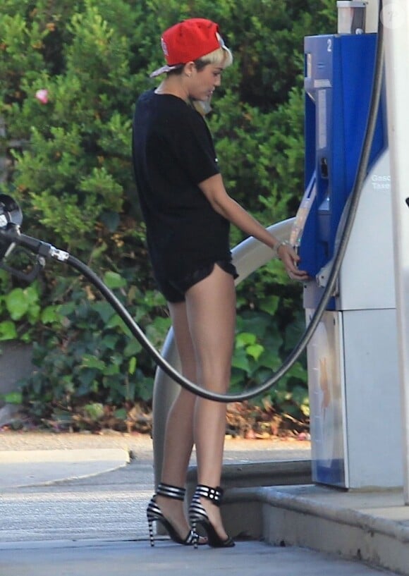 Exclusif - Miley Cyrus, sexy en t-shirt Diamond Supply & Co., mini-short et souliers Saint Laurent pour faire le plein de son 4x4 Porsche Cayenne. Los Angeles, le 30 avril 2013.