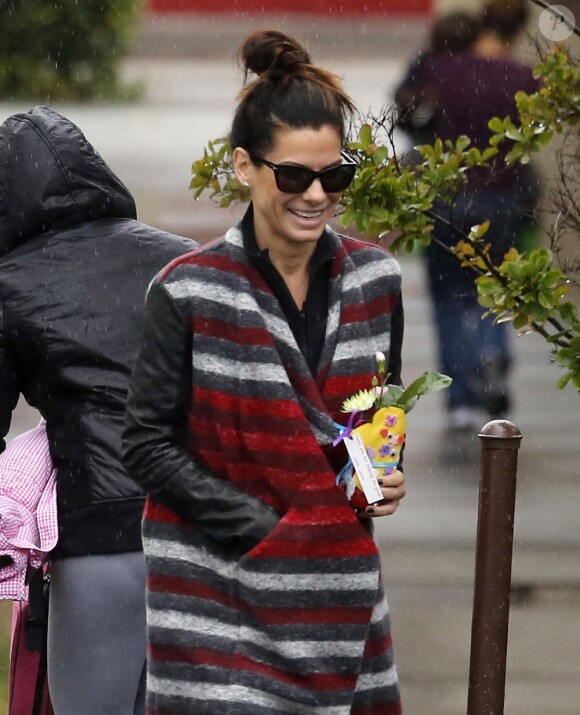 L'actrice Sandra Bullock a reçu des fleurs de son fils Louis, habillé en Superman à la sortie de l'école à Los Angeles, le 6 mai 2013.