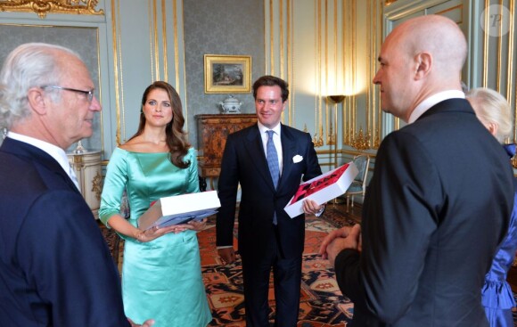 La princesse Madeleine de Suède et son fiancé Chris O'Neill recevant un cadeau du gouvernement au palais royal à Stockholm le 19 mai 2013 lors de la réception organisée à l'occasion de la publication de leurs bans, à trois semaines de leur mariage le 8 juin.