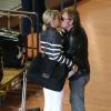 Johnny et Laeticia Hallyday partagent un baiser à leur arrivée en France avec leurs filles Joy et Jade et Eliette (la grand-mère de laeticia), à Paris le 21 mai 2013.
