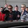Avant de monter dans leur voiture, Johnny et Laeticia Hallyday saluent une dernière fois les badauds, à l'aéroport de Paris, le 21 mai 2013.