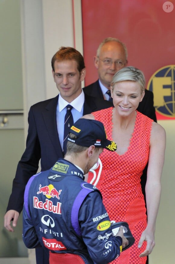 La princesse Charlene félicite Sebastian Vettel pour sa deuxième place, sous le regard d'Andrea Casiraghi, lors de la cérémonie de remise des trophées du Grand Prix de Monaco, le 26 mai 2013, remporté par Nico Rosberg.