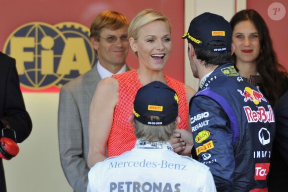 La princesse Charlene joyeuse face à Mark Webber, 3e du Grand Prix de Monaco remporté par Nico Rosberg, le 26 mai 2013. En arrière-plan, Tatiana Santo Domingo.