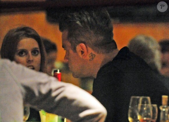 Robbie Williams en pleine converstion avec la princesse Beatrice lors d'un dîner à Londres, le 31 mai 2013.