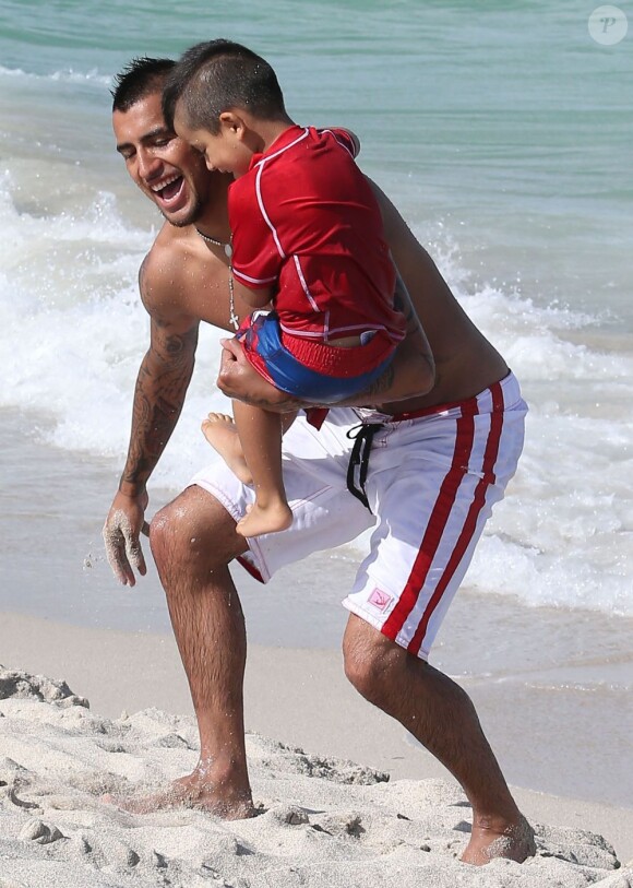 Arturo Vidal, heureux e, compagnie de son fils Alonso lors d'une journée ensoleillée sur la plage de Miami, le 29 Juin 2013