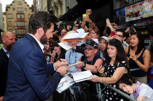 Hugh Jackman signe des autographes à la première mondiale du film Wolverine à Londres le 16 juillet 2013.