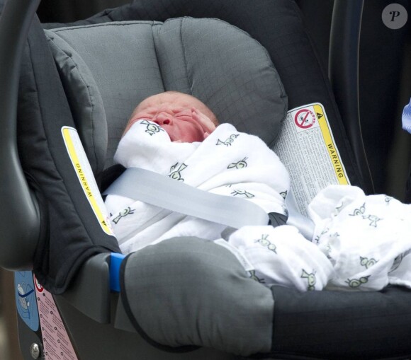Le prince George de Cambridge, âgé d'un jour quittant la maternité de l'hôpital St Mary avec ses parents le prince William et Kate Middleton le 23 juillet 2013, à Londres.