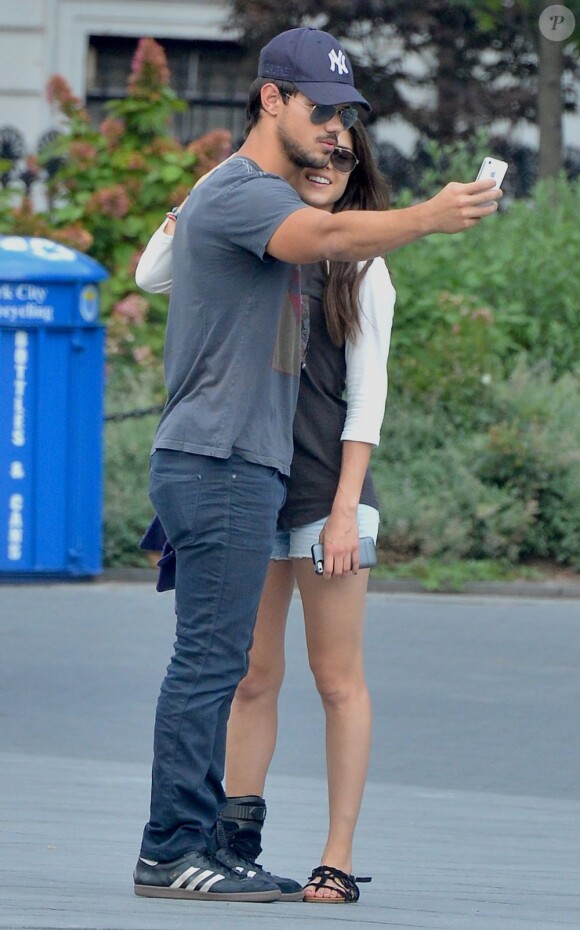 Taylor Lautner et Marie Avgeropoulos immortalisent leur romance sur smartphone à SoHo, New York, le 29 juillet 2013.