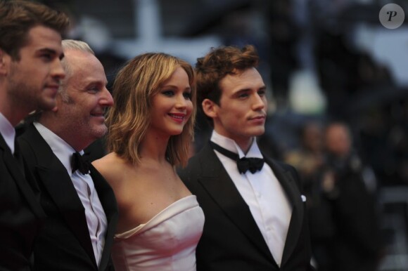 Sam Claflin au côté de Jennifer Lawrence pour monter les marches et soutenir le film Hunger Games : L'Embrasement à Cannes, le 18 mai 2013.